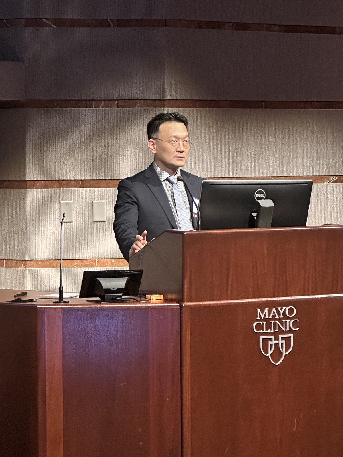 Dr. Min-Hee Ryu speaking at a lectern marked Mayo Clinic